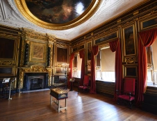 A grand room with an ornate fireplace and domed painted ceiling.