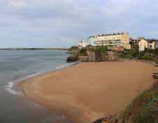 A sandy beach in a cliff-sided cove. 