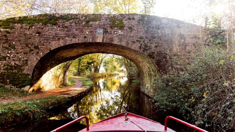 View from a narrowboat approaching a bridge.