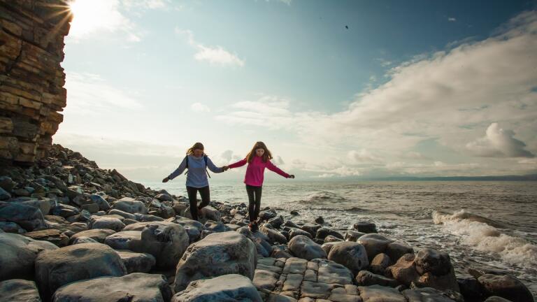 Two young people on the rocky seashore near Llantwit Major.