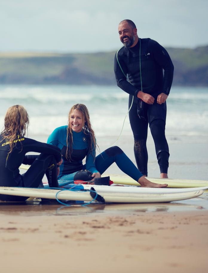 Kirsty Jones on the beach with friends and surfboards