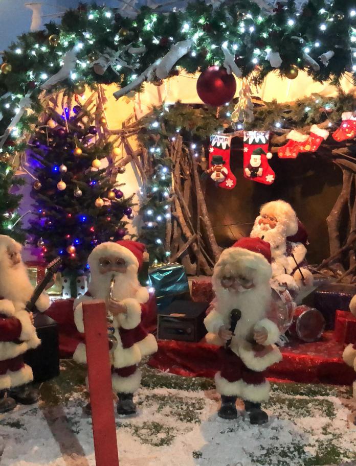 A Christmas scene with five small Santa figures.