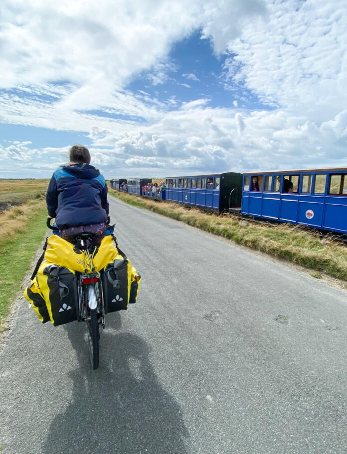Cycling through the countryside past a small blue train
