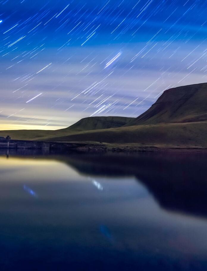 star trails over lake.