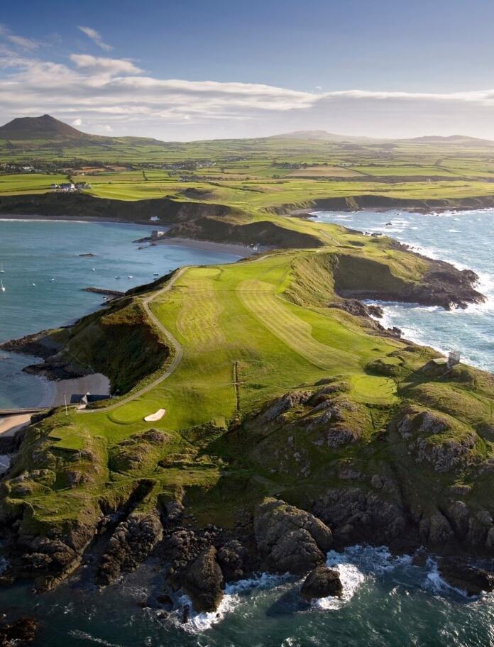 Aerial view of Nefyn golf course on a peninsula stretching out to sea
