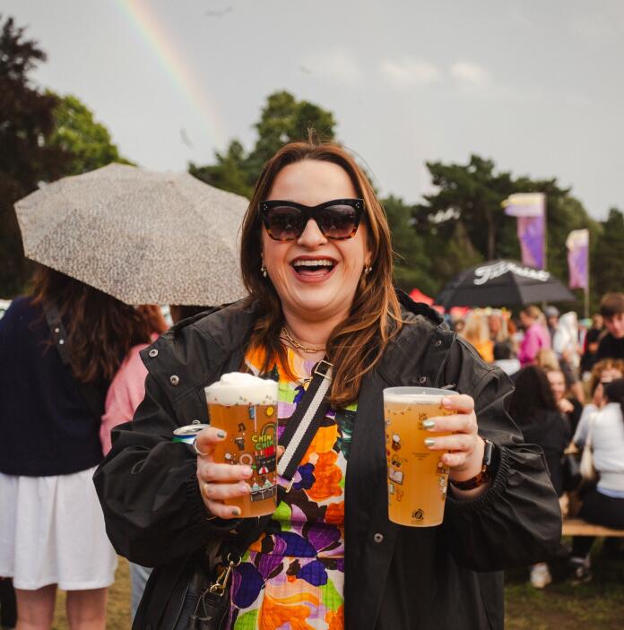 woman at festival holding drinks.
