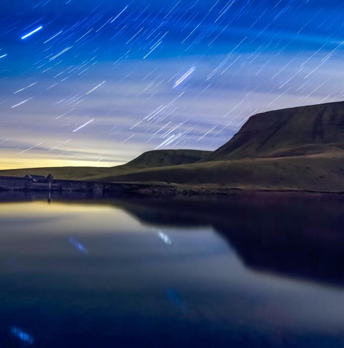 star trails over lake.