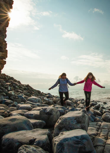 Two young people on the rocky seashore near Llantwit Major.