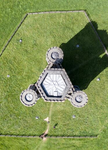 An aerial view of a hexagonal tower with three round towers off the sides.