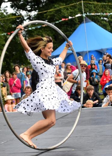 A woman in a rolling hoop on a stage.