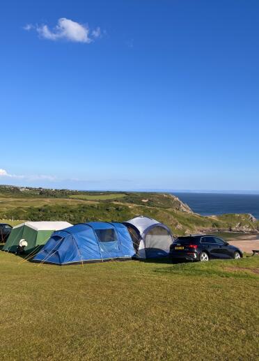 A campsite on a cliff overlooking a beach.