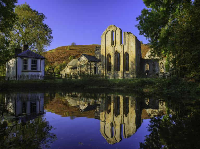 A ruined abbey reflected in a pond.