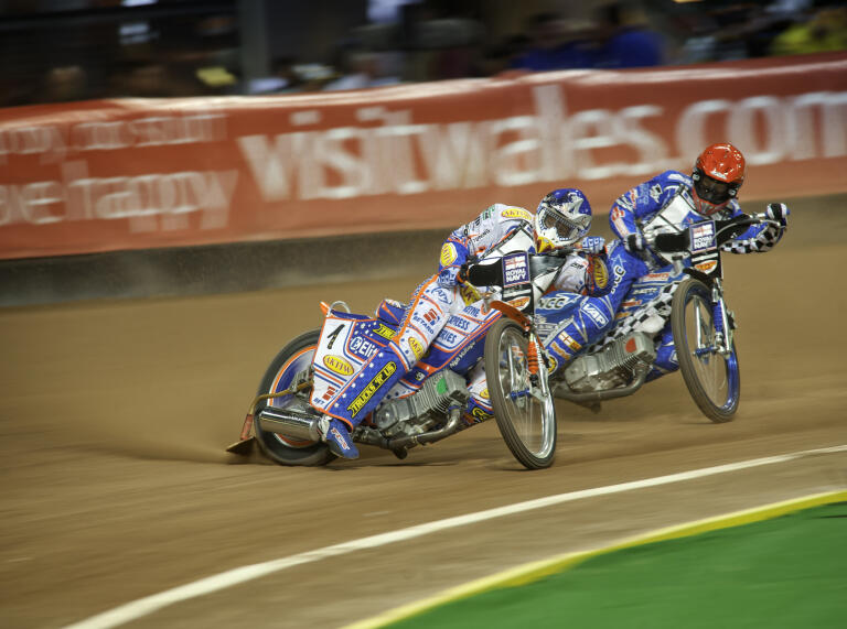 Two bikes racing along the dirt track.