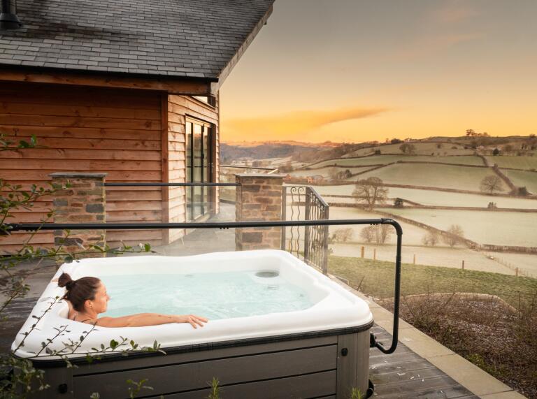 woman in hot tub with views of coutryside.