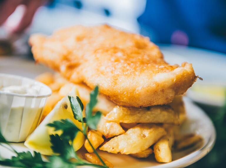 A plate of battered fish and chips.