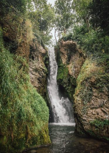 Ein hoher, fließender Wasserfall, der in eine Schlucht stürzt.
