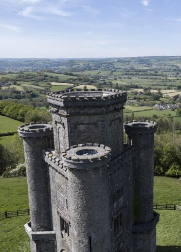 A castle tower overlooking a green valley.