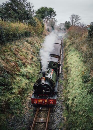 A steam train travelling through the countryside.