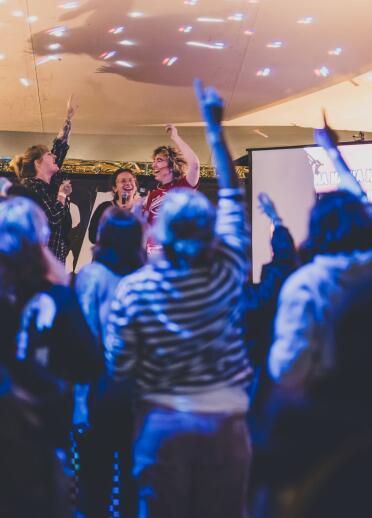 A group of happy people in a performance tent at a festival 