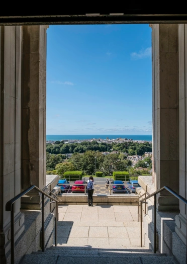 Blick auf das Meer von den Stufen und dem Eingang einer Nationalbibliothek.