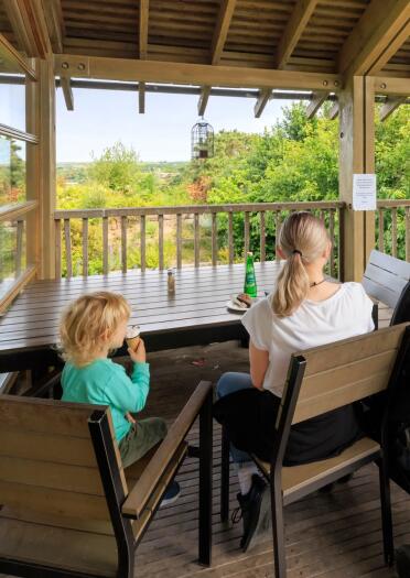 woman and child sat at a table of cafe, with views of wildlife centre.