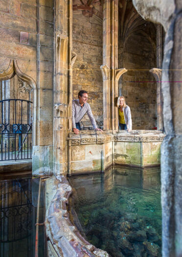 A couple inside a church looking into an tranquil baptismal pool