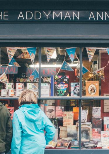 two people looking into a book shop window in Hay on Wye.