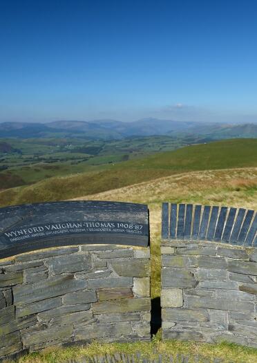 The view from a slate memorial on a hillside, looking over miles of rolling hills. 