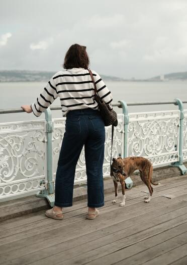 woman and Whippet dog on pier.