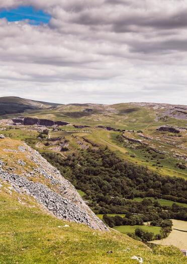 Two women walking on a hill with country views.