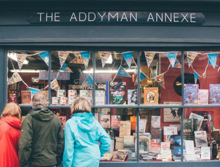 three people looking into a book shop window in Hay on Wye.