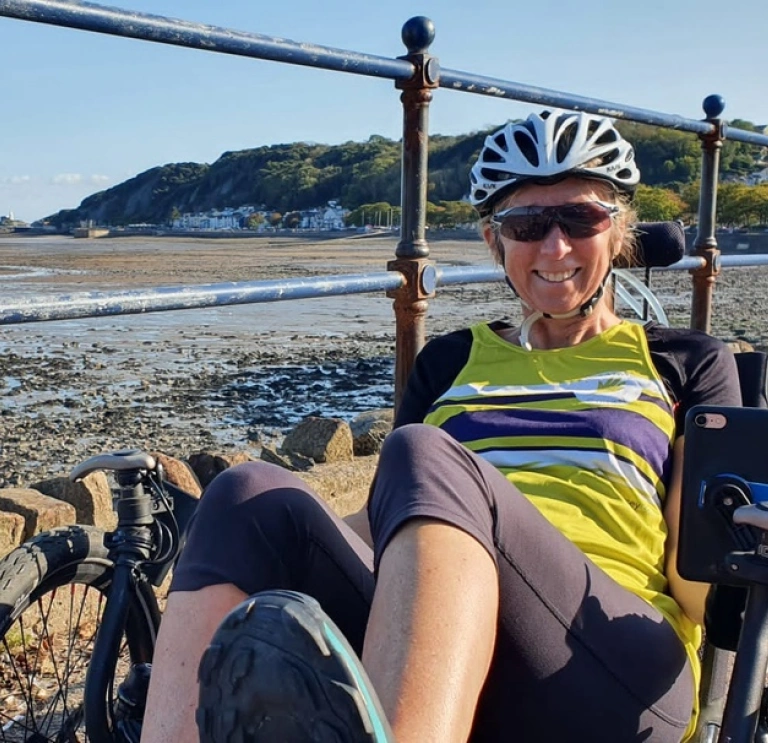 Frau auf einem Dreirad an der Strandpromenade.