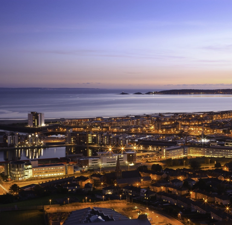 Aerial view over Swansea town at early evening toward Mumbles Head.