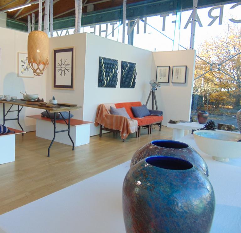 Image of the inside of a gallery with pottery, furniture and textiles on show