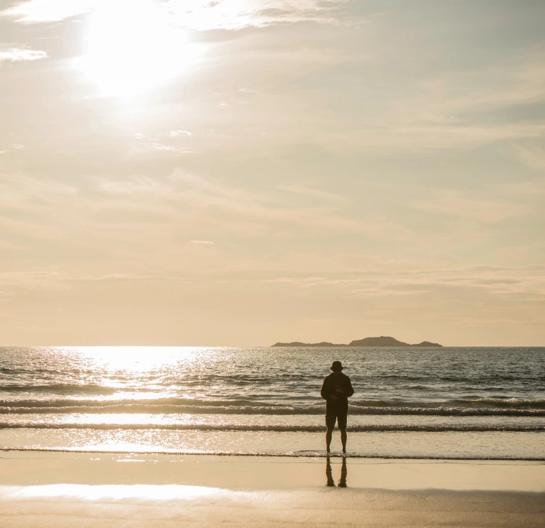 Man standing by sea at Whitesands Bay, Pembrokeshire, Westwales.