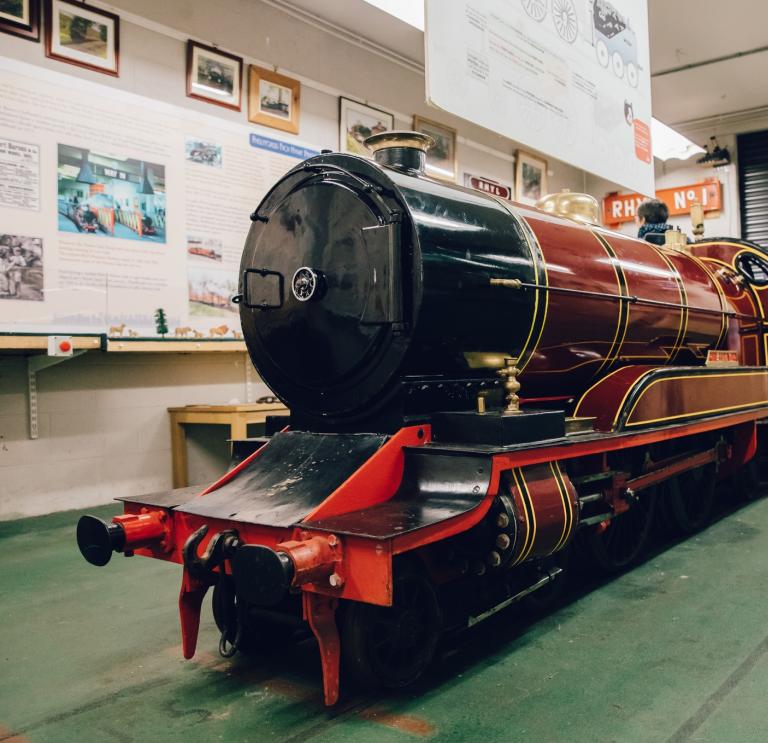 A red locomotive inside the museum at Rhyl Miniature Railway.