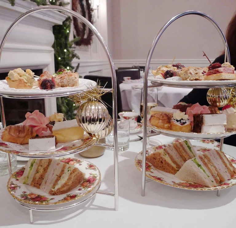 Afternoon tea on two silver serving dishes.