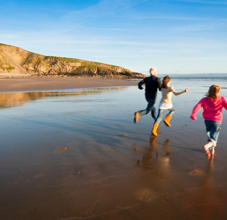 Image of a family running on the beach.