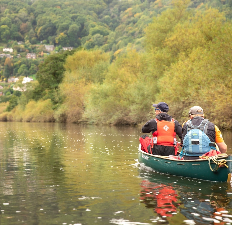 Two men canoeing down a river