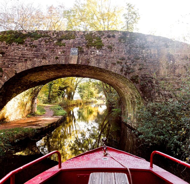 View from a narrowboat approaching a bridge.