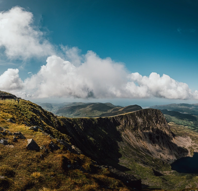 View from a mountaintop including the summit and towards the coast.