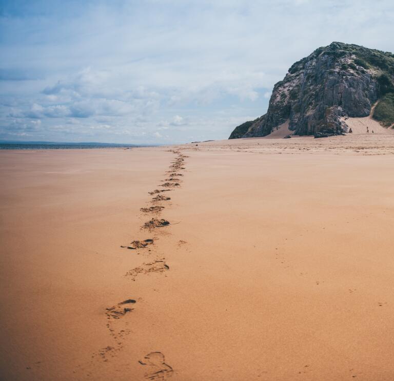 footsteps in sandy and cliff.