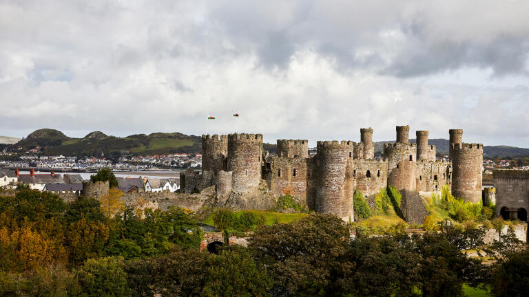 A large castle on the bank of a river.