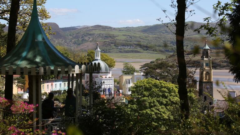 Italianate village and gardens with view across estuary.