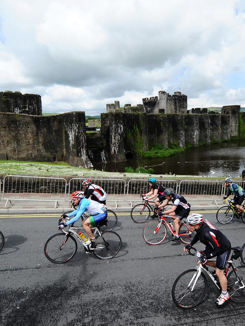 Image of Velothon Wales competitors cycling passed Caerphilly Castle