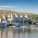 Looking across water to Castell Conwy, with boats in the harbour.