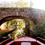 View from a narrowboat approaching a bridge.