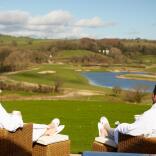 Couple relaxing at spa with view of a golf course.