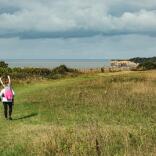 A woman giving a girl a piggy back on a coastal path near Llantwit Major.