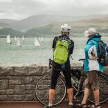 Two cyclists watching yachts.